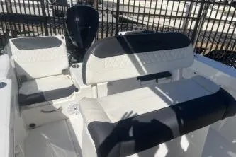 Slide: The Image of 2023 Trophy T22 boat interior with cushioned seating and motor, in a fenced area. - 6