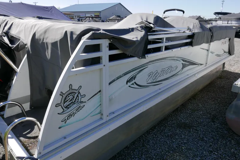 Slide: The Image of 2010 JC Neptoon 21TT pontoon boat covered and parked on gravel. - 14
