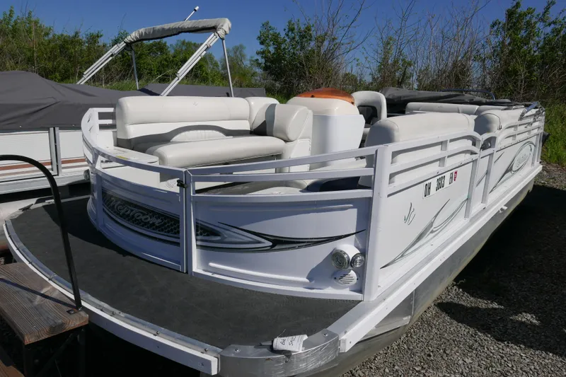 Slide: The Image of 2010 JC Neptoon 21TT pontoon boat with white seating and canopy, parked outdoors. - 2
