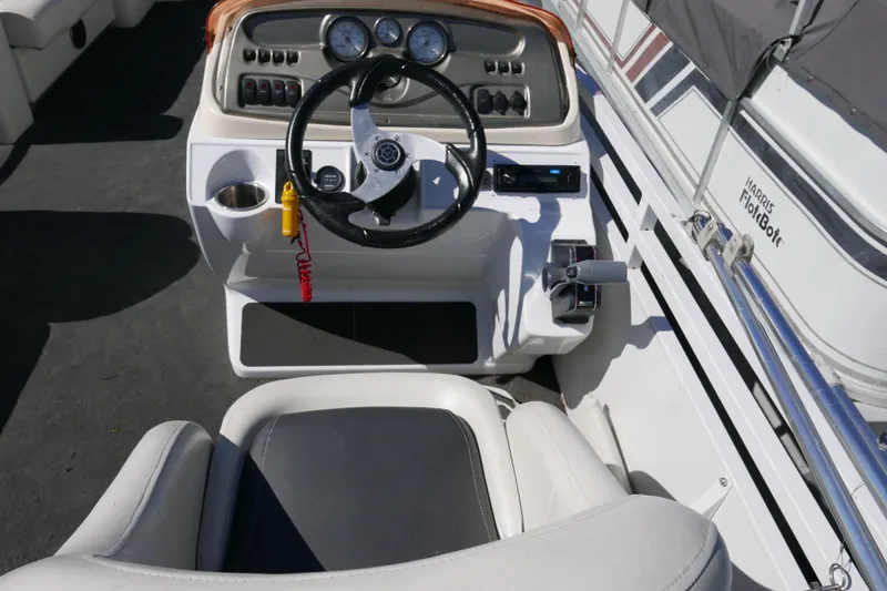 Slide: The Image of Cockpit of 2010 JC Neptoon 21TT pontoon boat with steering wheel and controls. - 8
