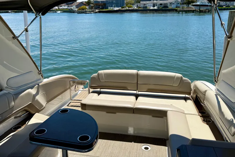 Slide: The Image of 2015 Formula 330 Crossover Bowrider interior with seating, table, and waterfront view. - 16
