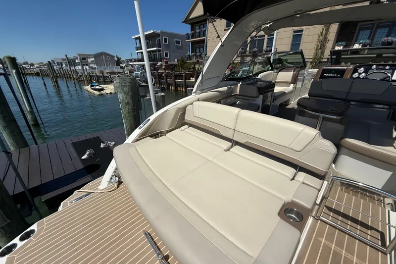 Slide: The Image of 2015 Formula 330 Crossover Bowrider docked, showcasing spacious seating and elegant design. - 17