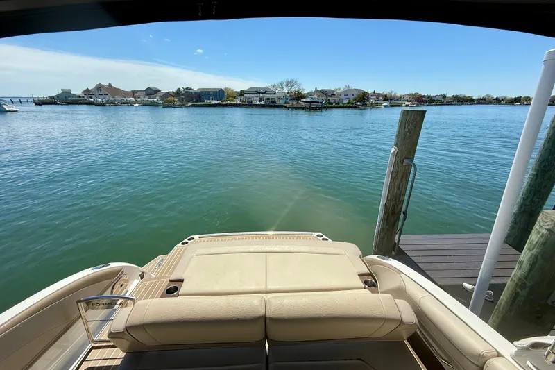 Slide: The Image of 2015 Formula 330 Crossover Bowrider docked, overlooking serene waterfront homes. - 18