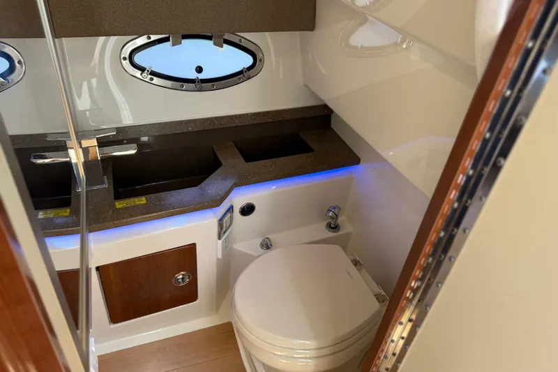 Slide: The Image of 2015 Formula 330 Crossover Bowrider bathroom with modern fixtures and porthole window. - 24