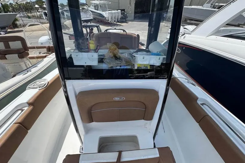 Slide: The Image of 2023 Sea Hunt Ultra 239 SE boat interior with brown seating and console. - 10