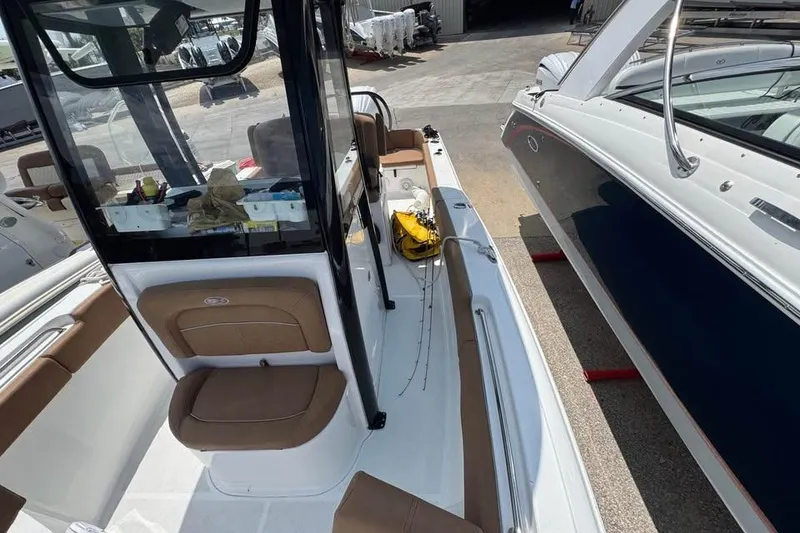 Slide: The Image of 2023 Sea Hunt Ultra 239 SE boat interior with seating and fishing rods. - 11