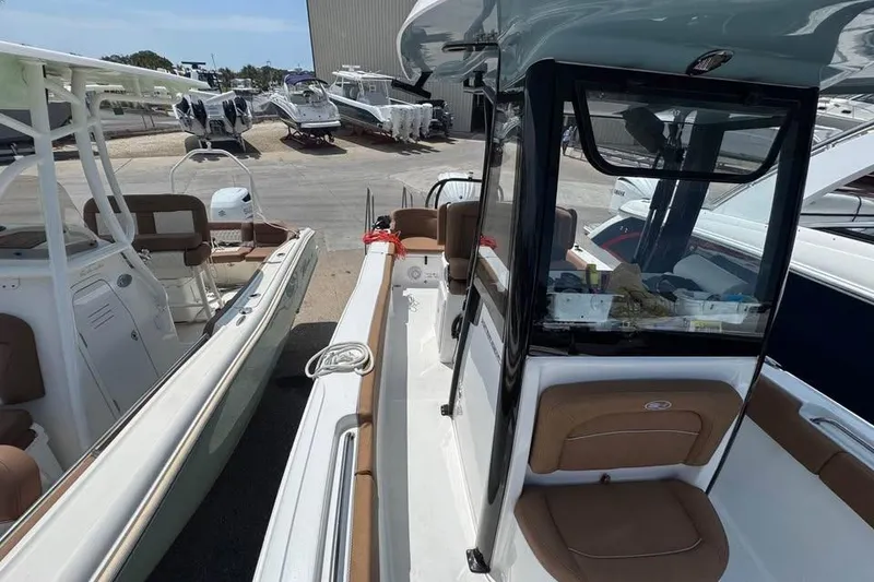 Slide: The Image of 2023 Sea Hunt Ultra 239 SE boat displayed at a marina, showcasing sleek design. - 12