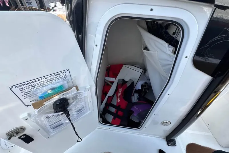Slide: The Image of Storage compartment on 2023 Sea Hunt Ultra 239 SE boat with safety gear and equipment. - 18