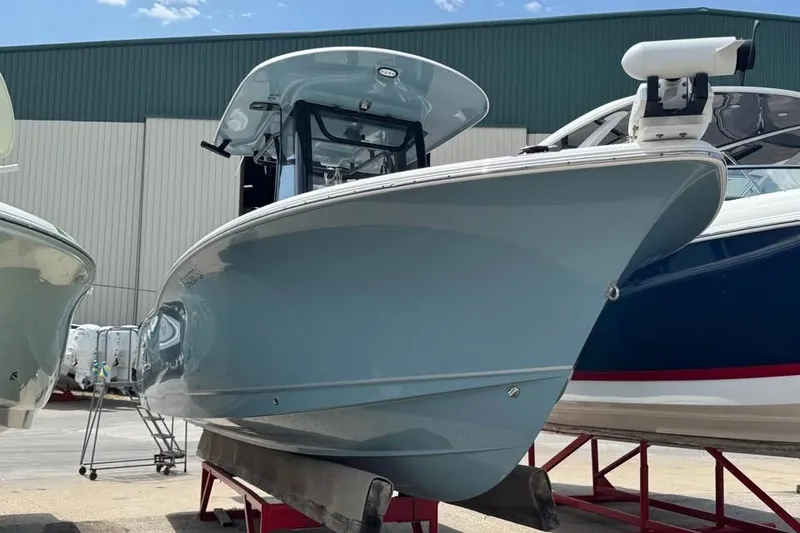 Slide: The Image of 2023 Sea Hunt Ultra 239 SE boat displayed outdoors on a stand. - 2