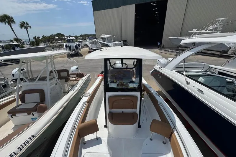 Slide: The Image of 2023 Sea Hunt Ultra 239 SE boat docked at a marina with other vessels. - 8