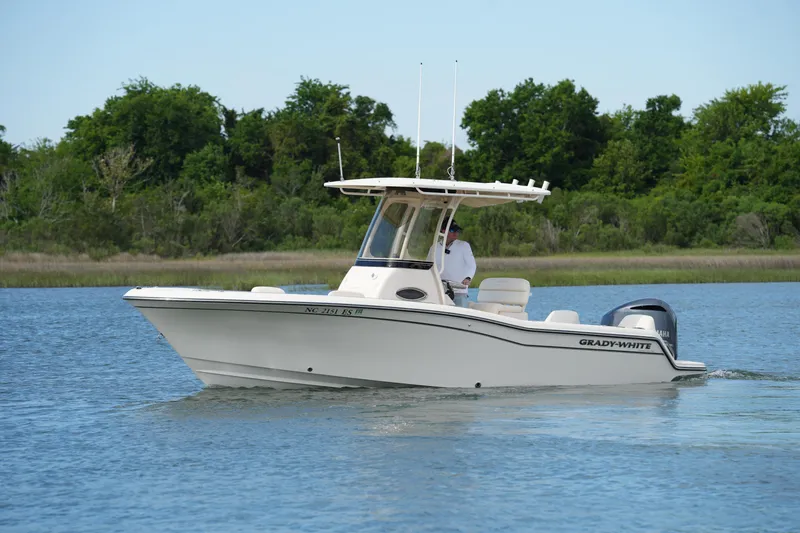 The Image of 2021 Grady-White Fisherman 216 boat cruising on a calm lake with lush greenery. - 0
