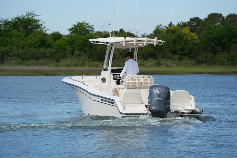 Slide: The Image of 2021 Grady-White Fisherman 216 boat cruising on a calm lake with lush greenery. - 10