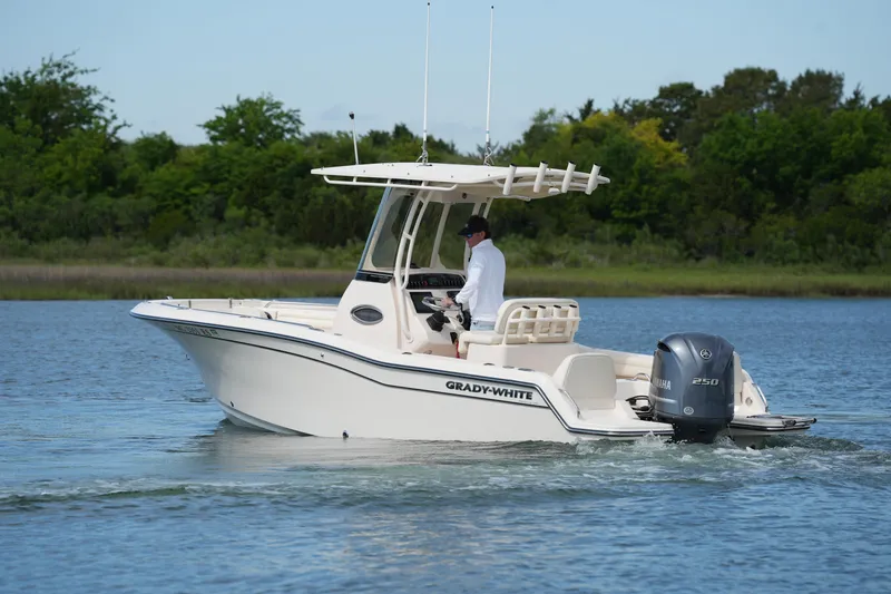 Slide: The Image of 2021 Grady-White Fisherman 216 boat cruising on a calm lake with lush greenery. - 11