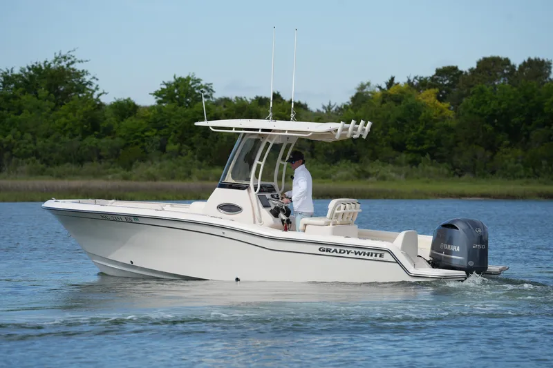 Slide: The Image of 2021 Grady-White Fisherman 216 boat cruising on a calm lake with lush greenery. - 12