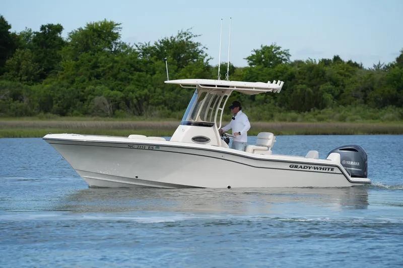 Slide: The Image of 2021 Grady-White Fisherman 216 boat cruising on a calm lake with lush greenery. - 13
