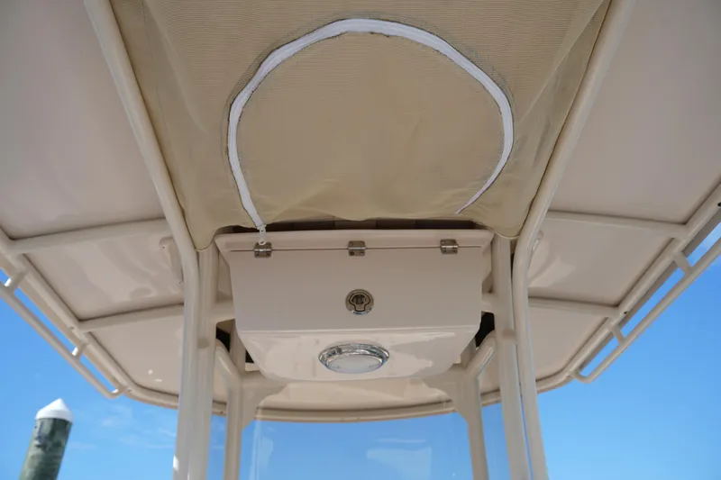 Slide: The Image of 2021 Grady-White Fisherman 216 boat canopy and storage compartment under clear blue sky. - 21