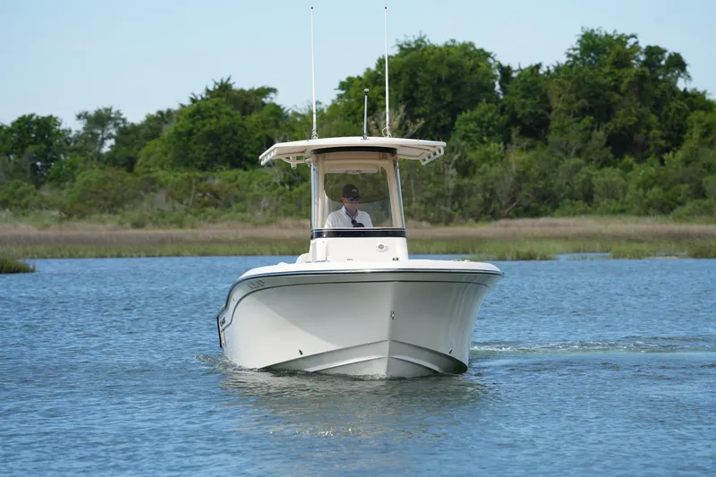 Slide: The Image of 2021 Grady-White Fisherman 216 boat cruising on a serene lake with lush greenery. - 3