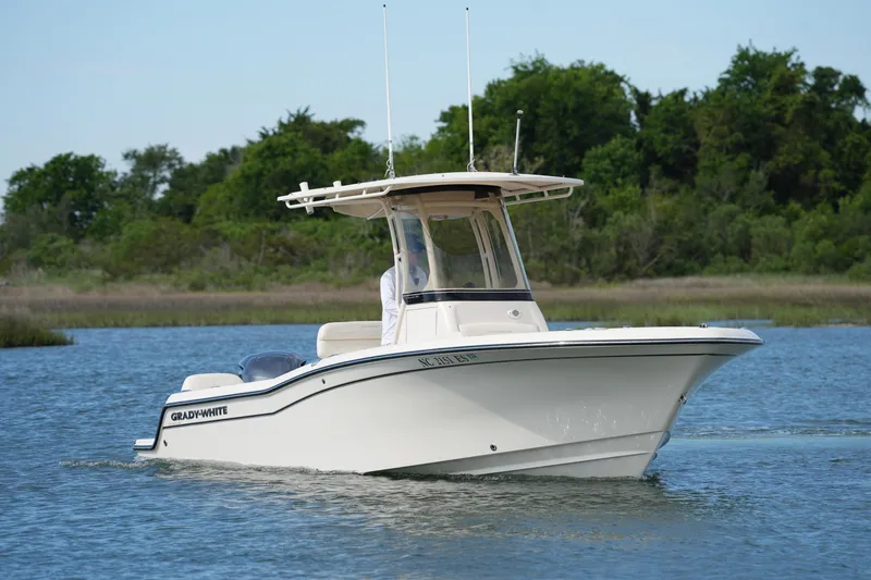 Slide: The Image of 2021 Grady-White Fisherman 216 boat cruising on a serene lake with lush greenery. - 4