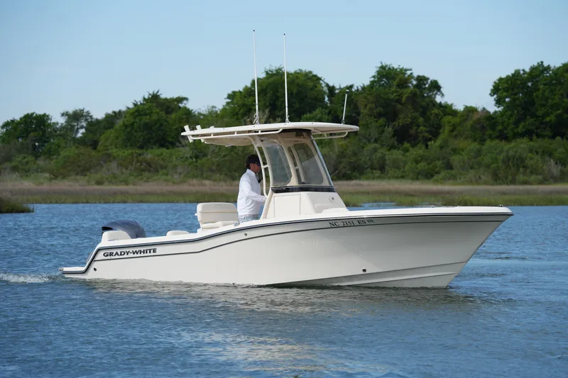 Slide: The Image of 2021 Grady-White Fisherman 216 boat cruising on a calm lake with lush greenery. - 5
