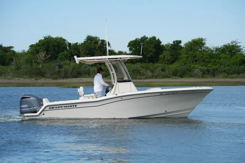 Slide: The Image of 2021 Grady-White Fisherman 216 boat cruising on a calm lake with lush greenery. - 6