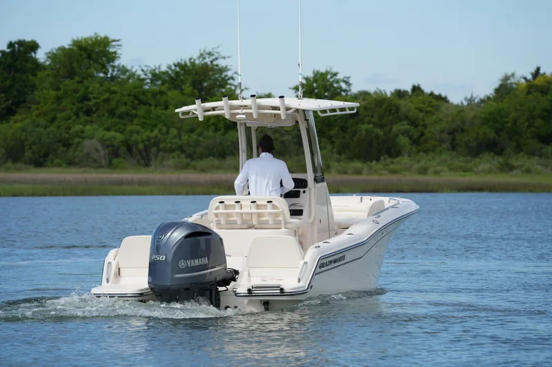 Slide: The Image of 2021 Grady-White Fisherman 216 boat cruising on a calm lake with lush greenery. - 8