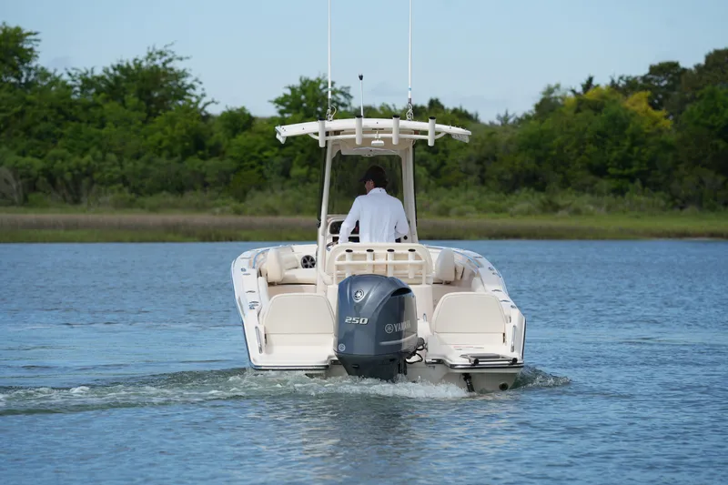 Slide: The Image of 2021 Grady-White Fisherman 216 boat cruising on a calm lake with lush greenery. - 9