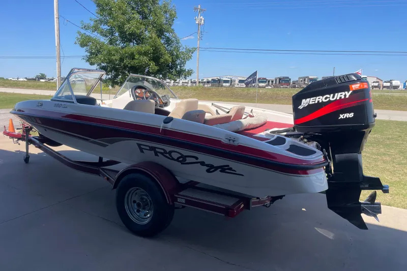 Slide: The Image of 2002 ProCraft 180 Combo boat with Mercury XR6 engine on trailer, parked outdoors. - 2