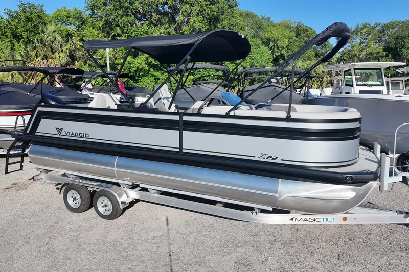 The Image of 2026 Viaggio Lago X-R 22 pontoon boat on trailer, parked outdoors. - 0