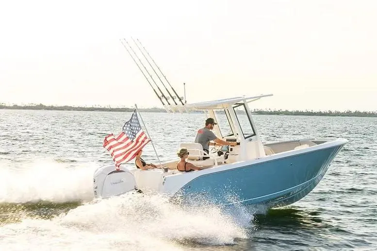 The Image of 2026 Sailfish 232 CC boat cruising on water with American flag waving. - 1