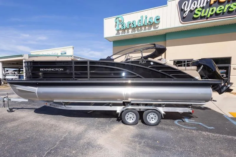 Slide: The Image of 2023 Bennington R23 Swingback pontoon boat on trailer outside dealership. - 1