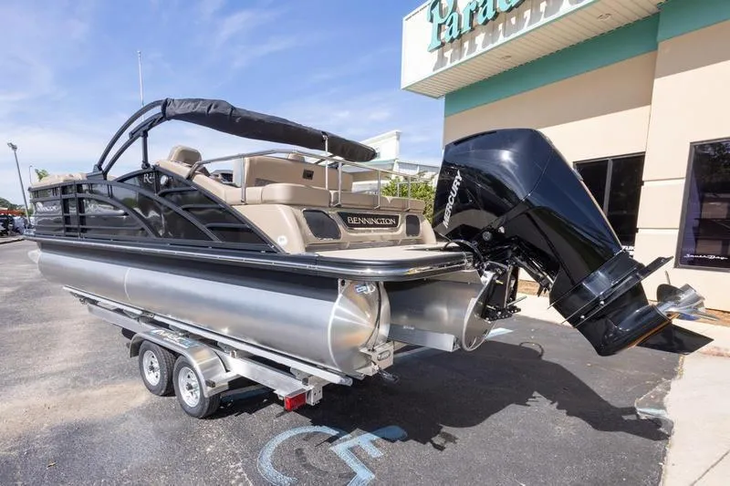 Slide: The Image of 2023 Bennington R23 Swingback pontoon boat on trailer, parked outside dealership. - 2