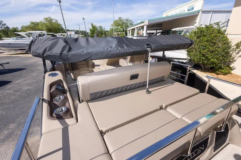 Slide: The Image of 2023 Bennington R23 Swingback boat with beige seating and canopy, docked outdoors. - 20