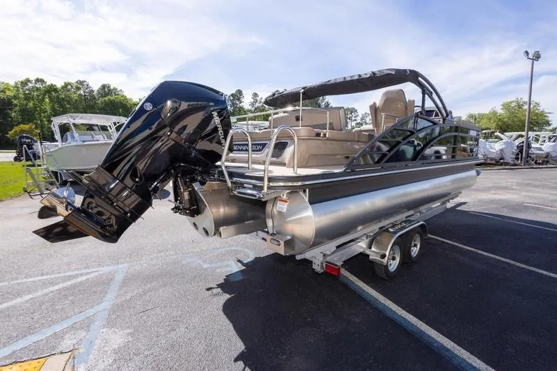 Slide: The Image of 2023 Bennington R23 Swingback pontoon boat on trailer, featuring sleek design and powerful outboard motor. - 3