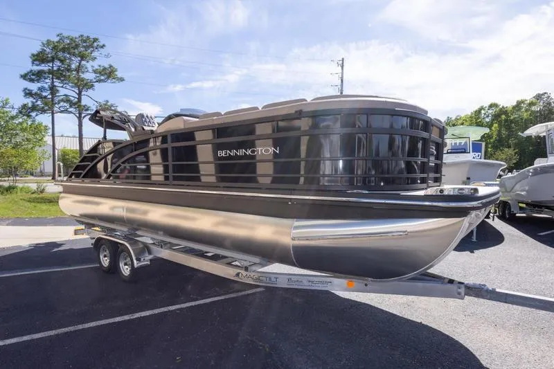 Slide: The Image of 2023 Bennington R23 Swingback pontoon boat on trailer, parked outdoors. - 5