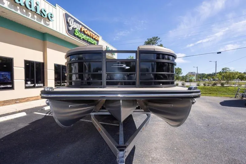 Slide: The Image of 2023 Bennington R23 Swingback pontoon boat displayed at a dealership. - 6