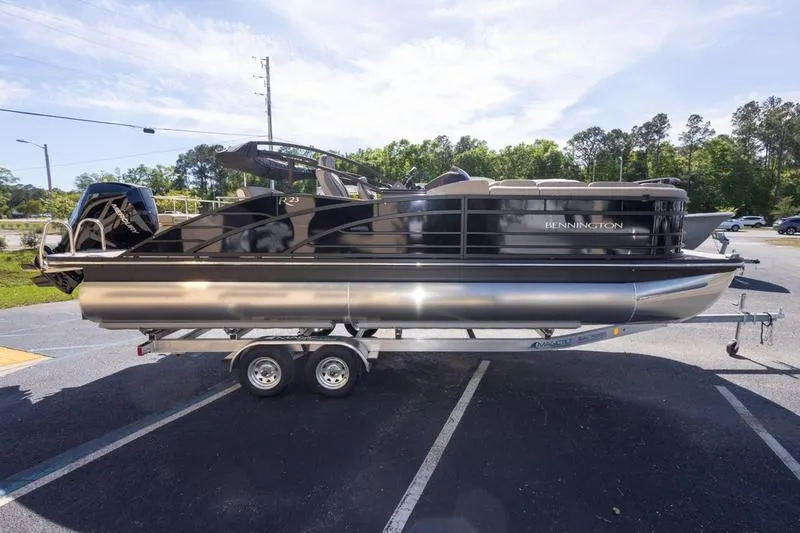 Slide: The Image of 2023 Bennington R23 Swingback pontoon boat on trailer, parked outdoors. - 7