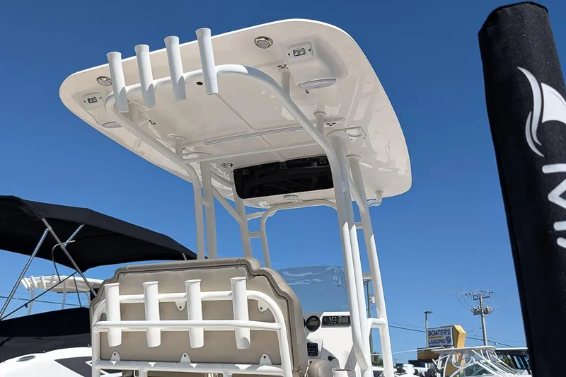 Slide: The Image of 2022 Key West 230 Bay Reef boat with T-top and rod holders under clear blue sky. - 23
