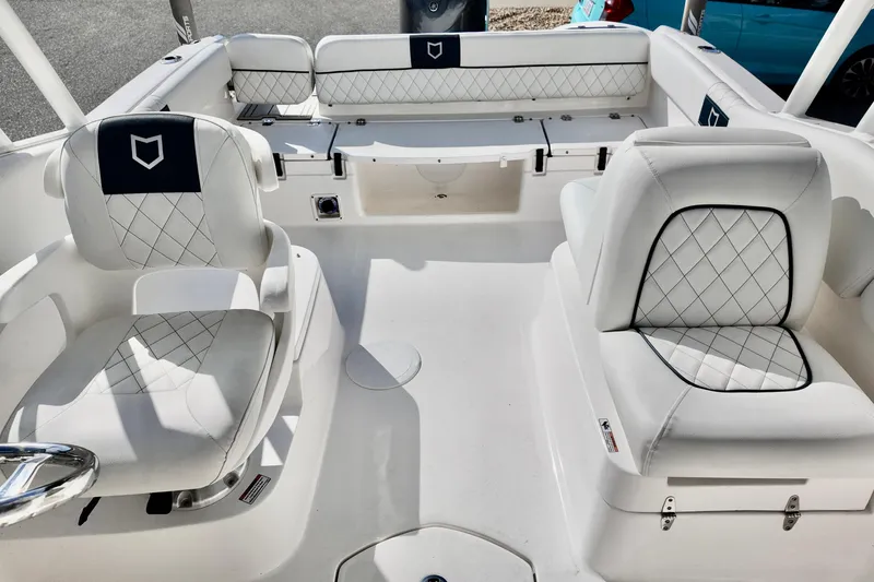 Slide: The Image of 2024 Sea Fox 228 Commander boat interior with white cushioned seating and diamond stitching. - 12