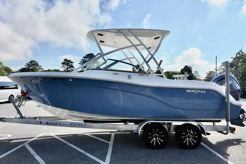 Slide: The Image of 2024 Sea Fox 228 Commander boat on trailer under blue sky. - 2