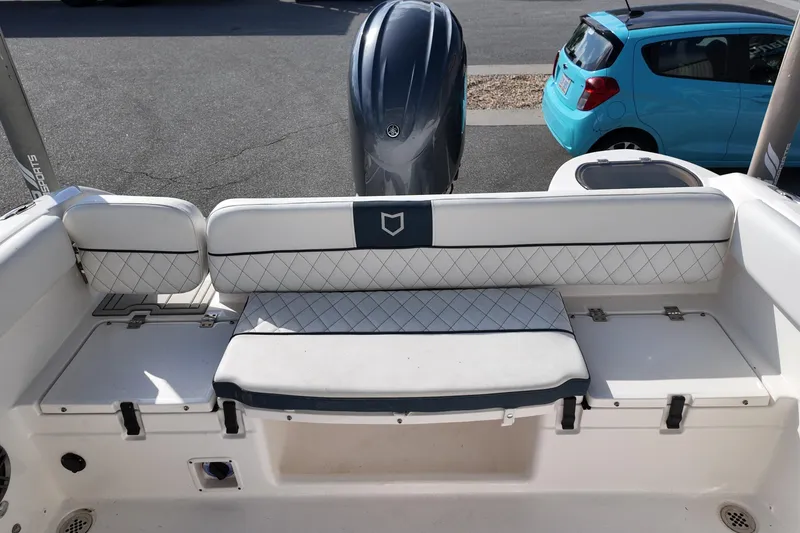 Slide: The Image of 2024 Sea Fox 228 Commander boat interior with cushioned seating and motor view. - 20