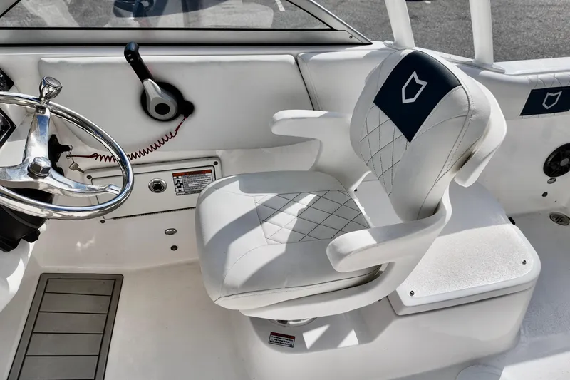 Slide: The Image of 2024 Sea Fox 228 Commander helm with steering wheel and cushioned captain's chair. - 6