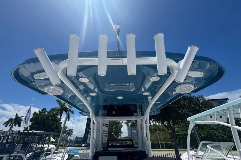 Slide: The Image of 2026 Sea Pro 242 Center Console boat with rod holders and blue sky. - 16