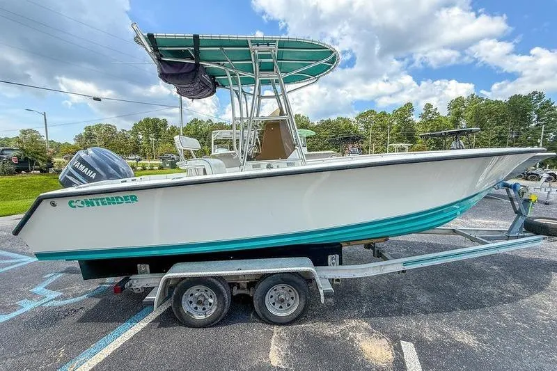 Slide: The Image of 1997 Contender 21 Open boat on trailer, parked outdoors under a partly cloudy sky. - 3