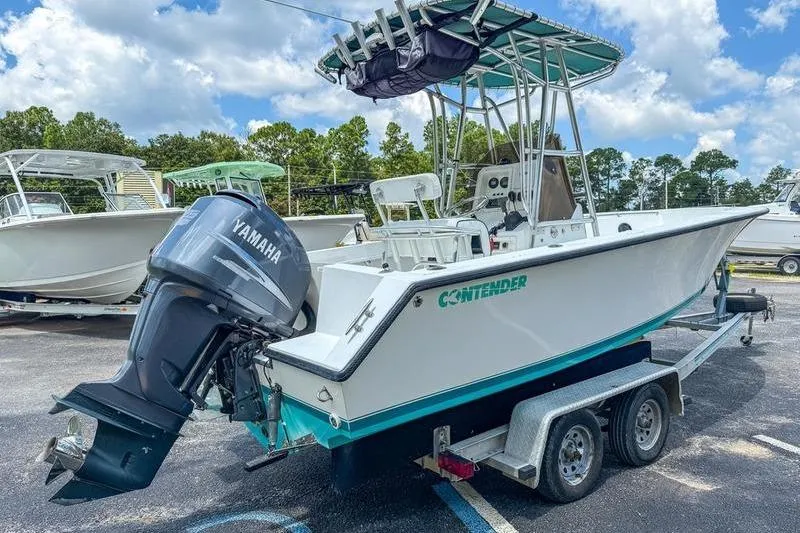 Slide: The Image of 1997 Contender 21 Open boat with Yamaha outboard motor on trailer, parked outdoors. - 4