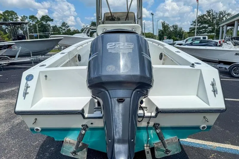 Slide: The Image of 1997 Contender 21 Open boat with a 225 horsepower outboard motor, parked outdoors. - 5