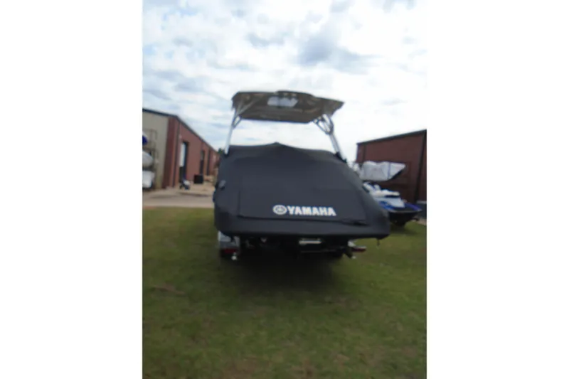 Slide: The Image of 2022 Yamaha Boats 275SD covered, parked outdoors near buildings. - 3