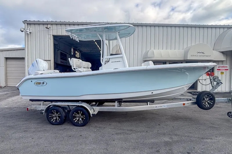 The Image of 2026 Sea Hunt Ultra 219 boat on trailer outside workshop. - 1