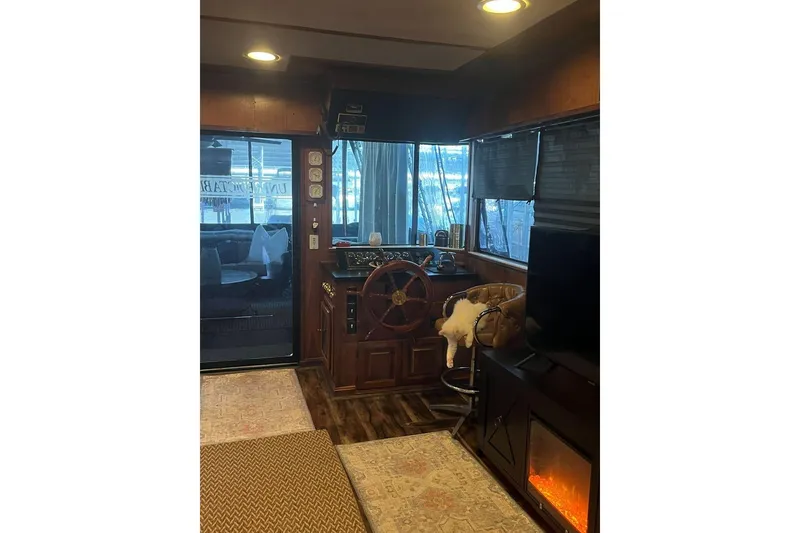 Slide: The Image of Interior of a 1985 Sumerset 18x81 houseboat with helm, cozy seating, and fireplace. - 11