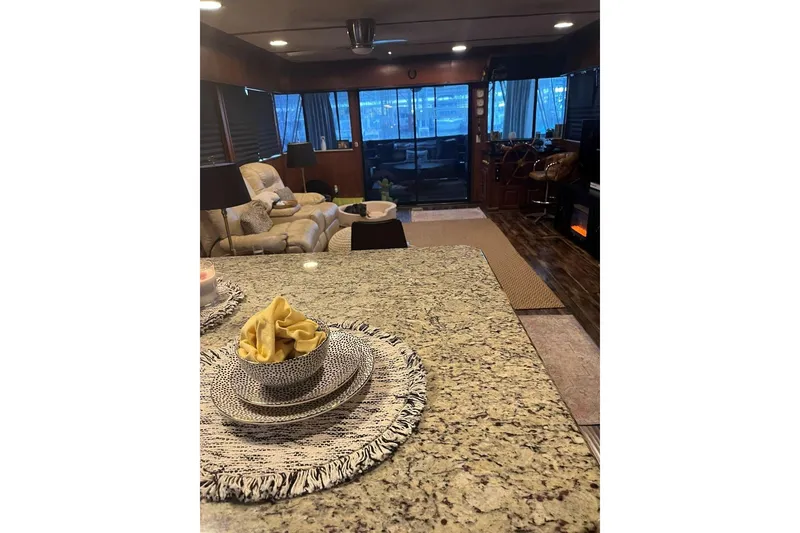 Slide: The Image of Interior of 1985 Sumerset 18x81 houseboat with cozy seating and elegant dining setup. - 14