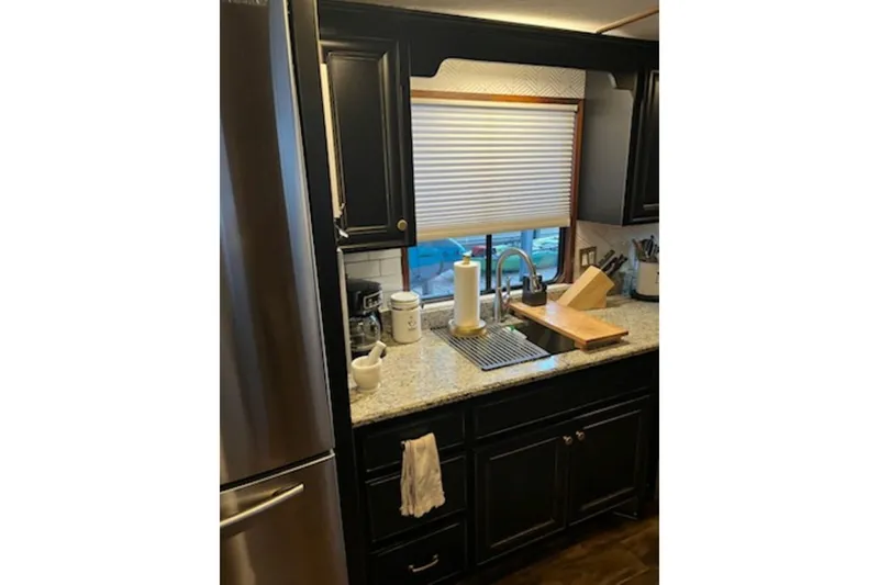 Slide: The Image of Modern kitchen in 1985 Sumerset 18x81 houseboat with granite countertops and stainless steel appliances. - 17